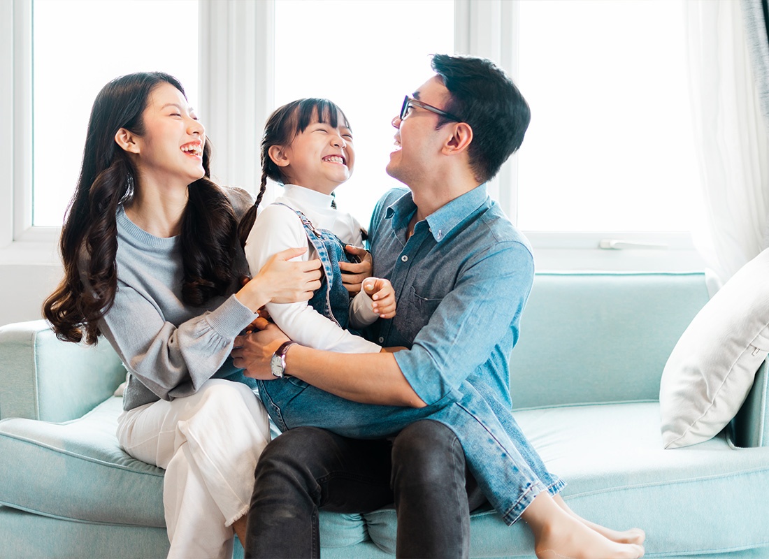 Personal Insurance - Young Family Spending Time Together and having Fun on Their Sofa in Their Living Room at Home